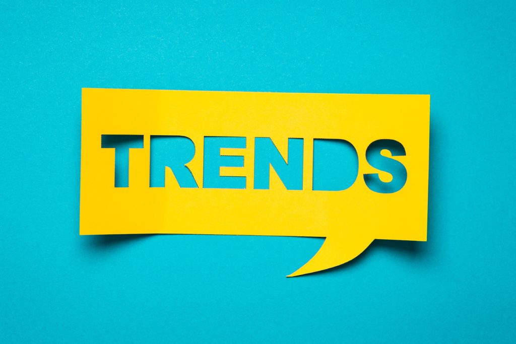 Turquoise image with yellow cutout paper that reads trends
